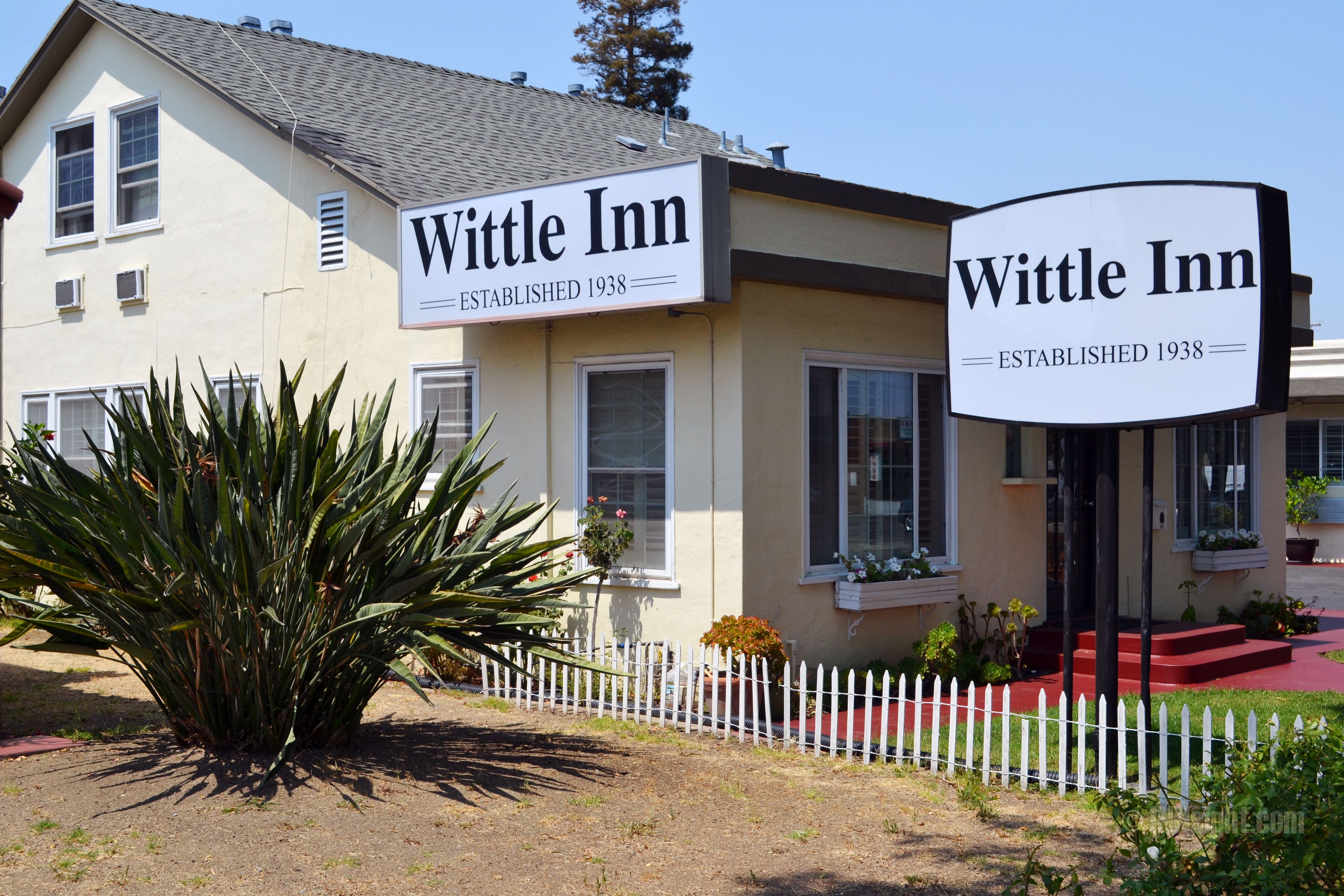 A two-story building with a sign reading "Wittle Inn Established 1938" on the facade.