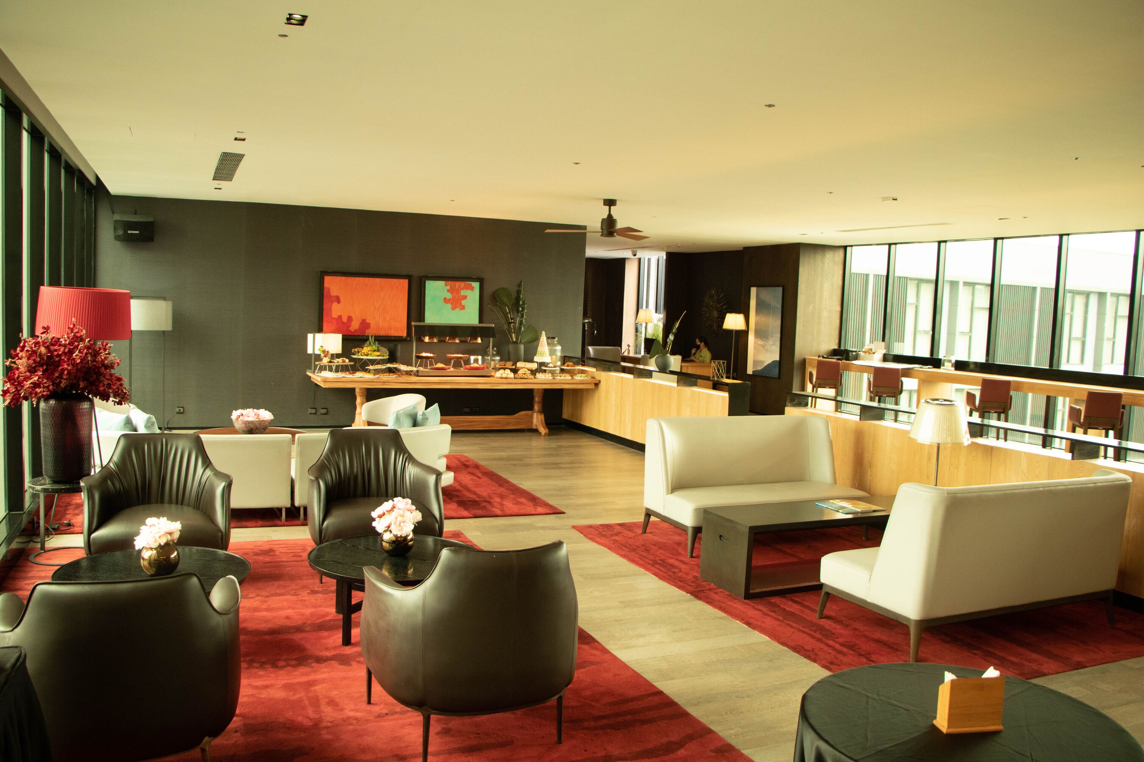 A modern hotel lobby with leather sofas, a pool table, and a bar area.