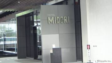 A modern hotel entrance with a sign reading "HOTEL MIDORI".