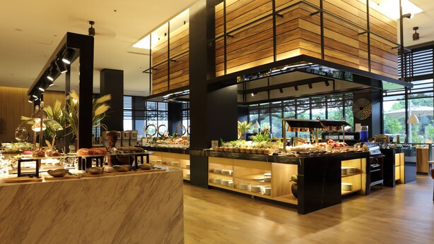 A buffet area with marble countertops, wooden paneling, and a variety of food items.