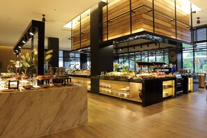 A buffet area with marble countertops, wooden paneling, and a variety of food items. - Midori Clark Hotel and Casino (Mabalacat City)