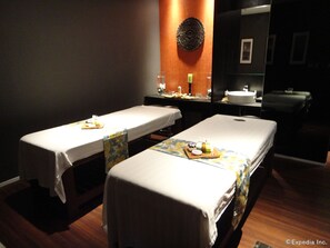 A room with two massage tables, each with a towel and a tray of snacks. There is a mirror above the tables and a sink in the background. - Midori Clark Hotel and Casino (Mabalacat City)