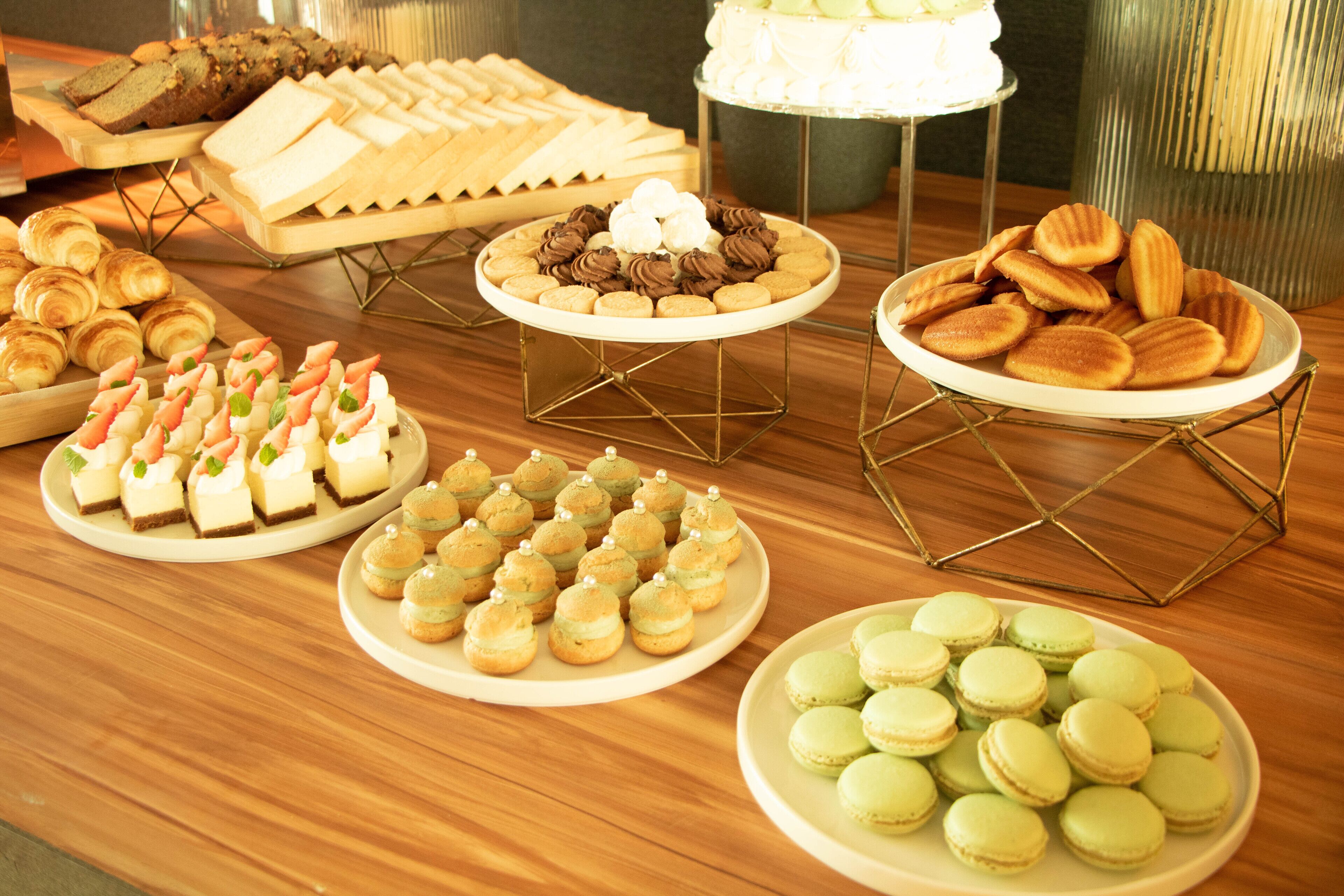 A buffet table with various desserts and pastries.