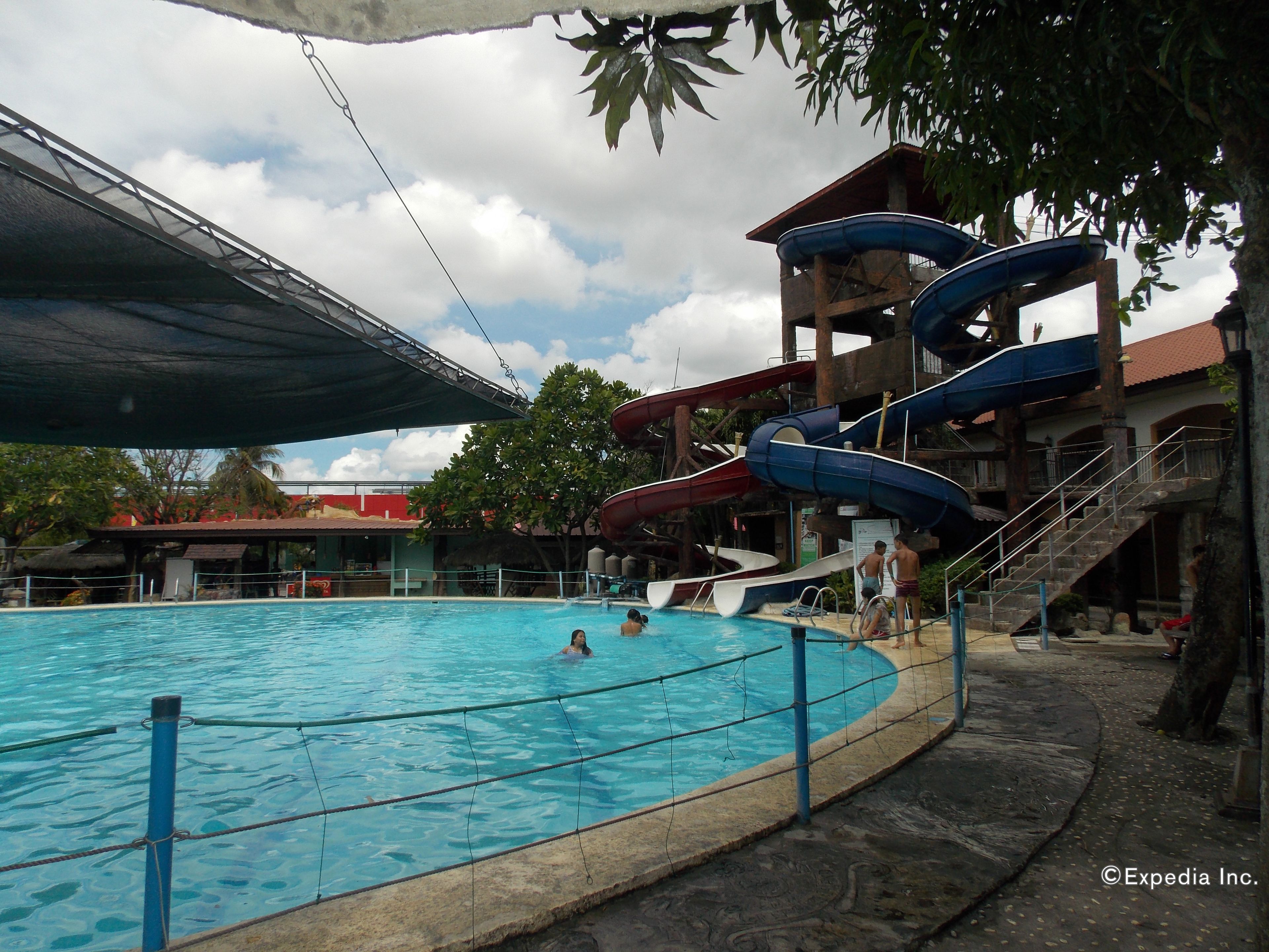 A swimming pool with slides and a covered area.
