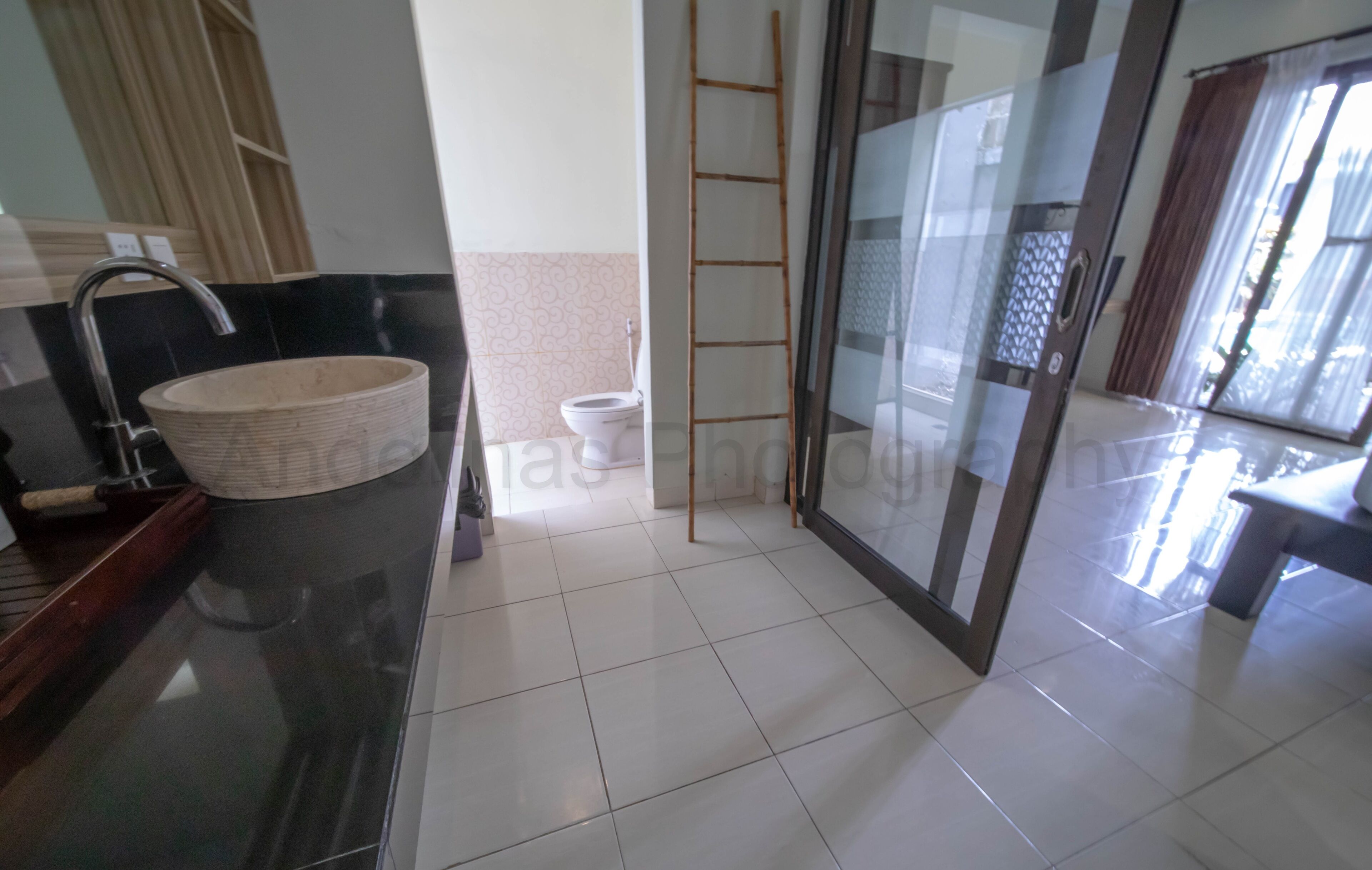 Ein modernes Badezimmer mit großem Spiegel, Waschbecken, Toilette und einer Duschkabine aus Glas.