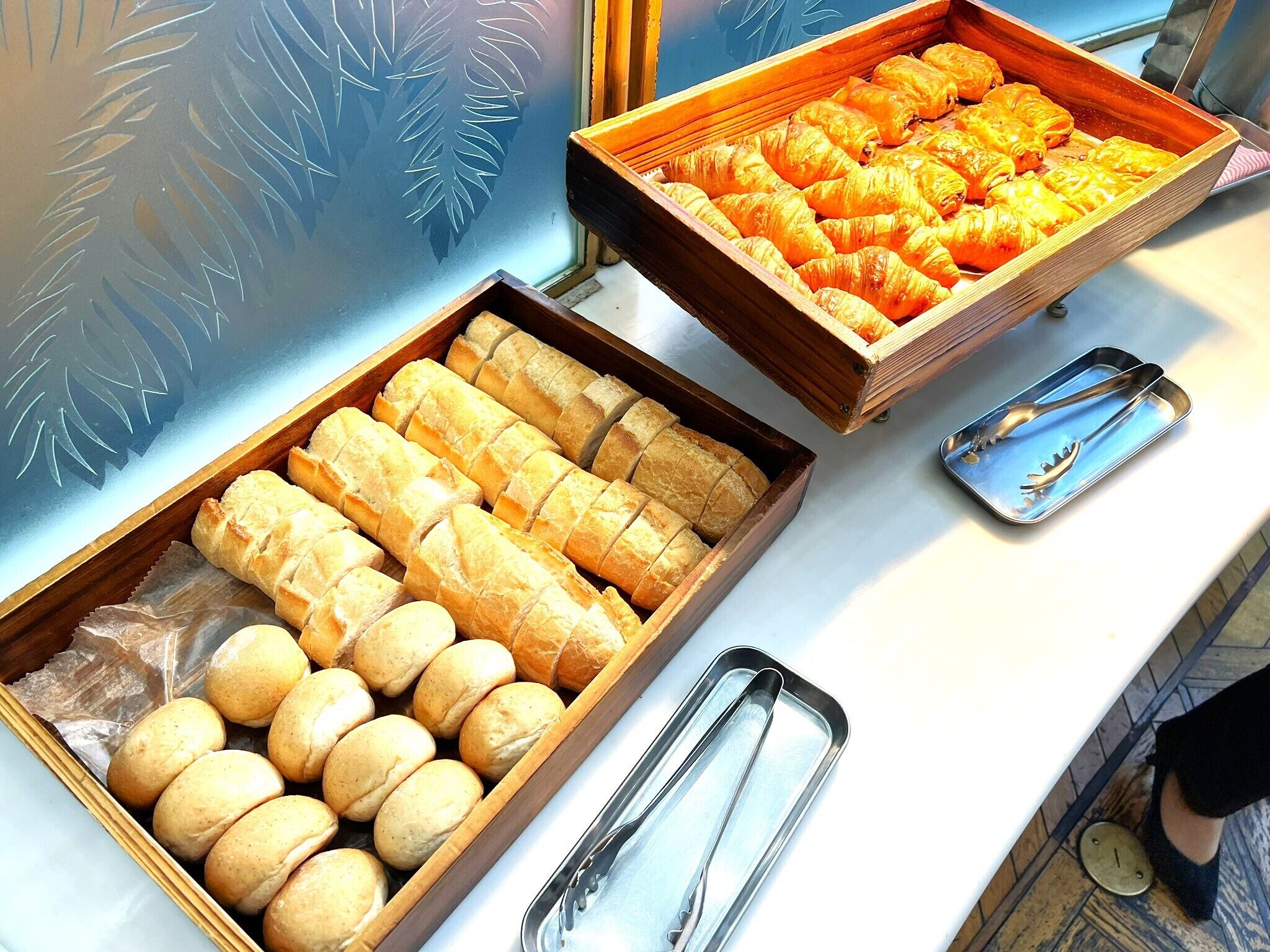 A breakfast buffet with various baked goods and serving utensils.
