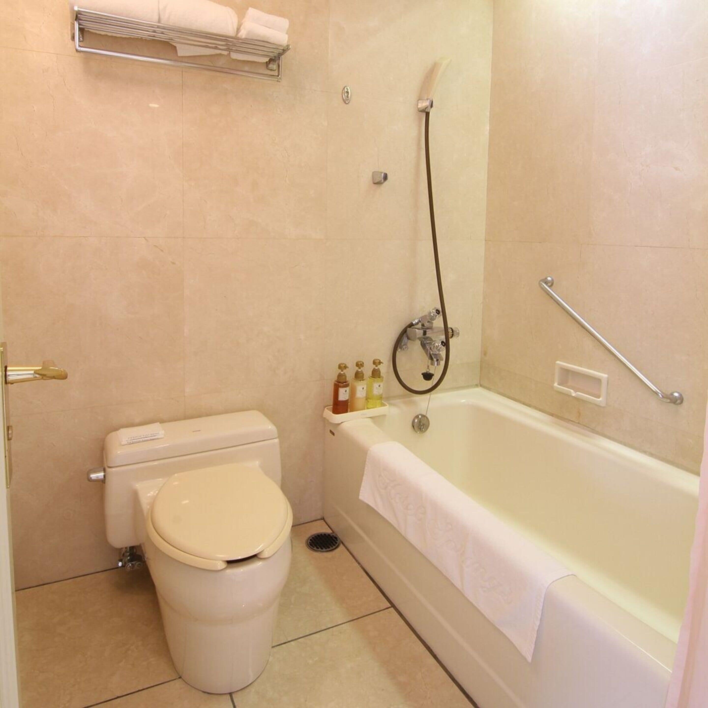 A bathroom with a toilet, a bathtub, and a shower.