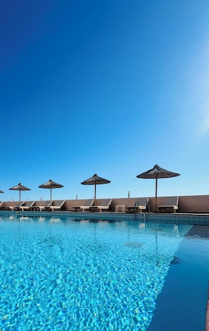 A swimming pool with lounge chairs and umbrellas. - Saradari Beach Hotel - Adults Only (Hersonissos)