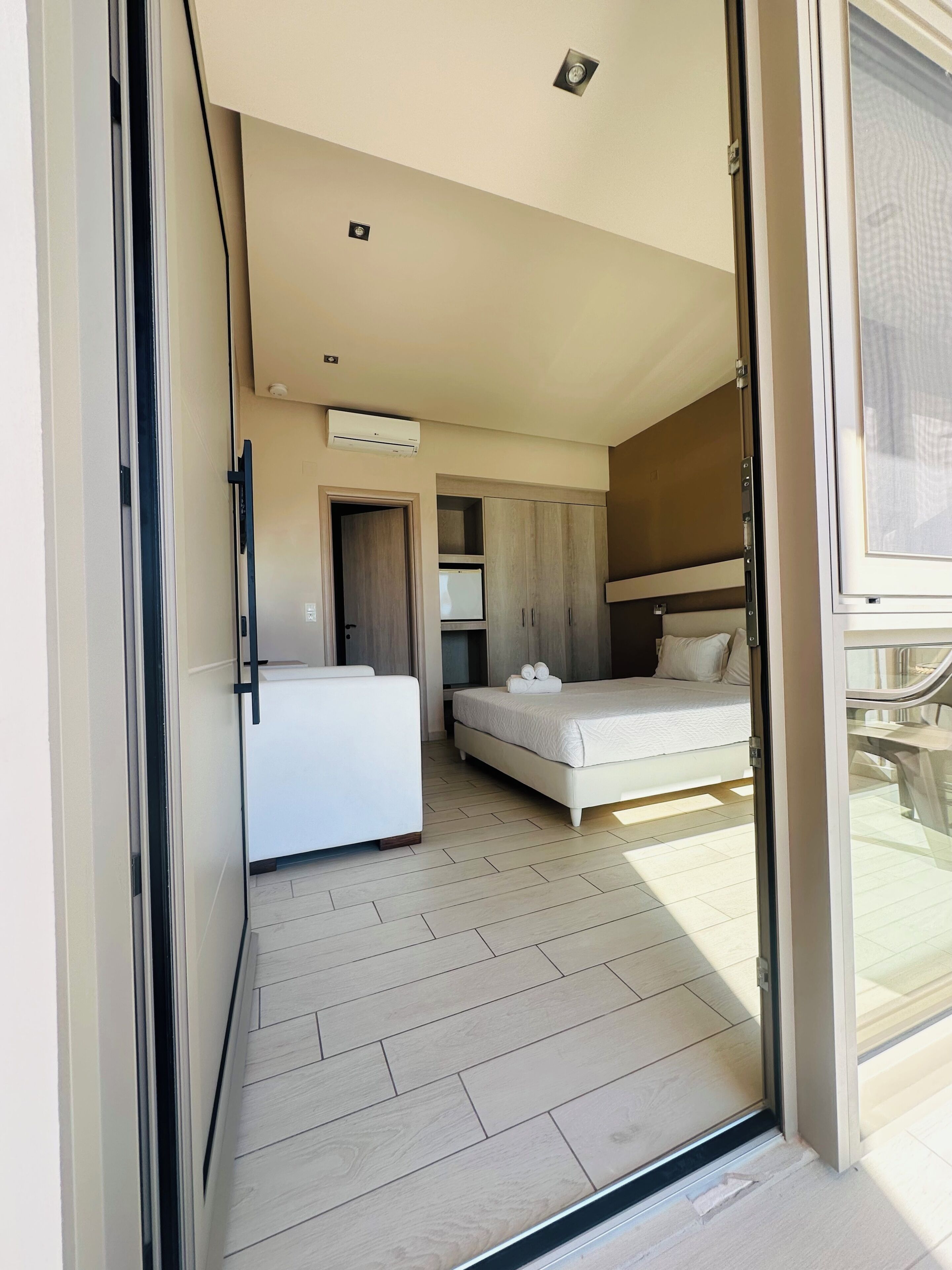 A modern bedroom with a bed, a desk, and a wardrobe.