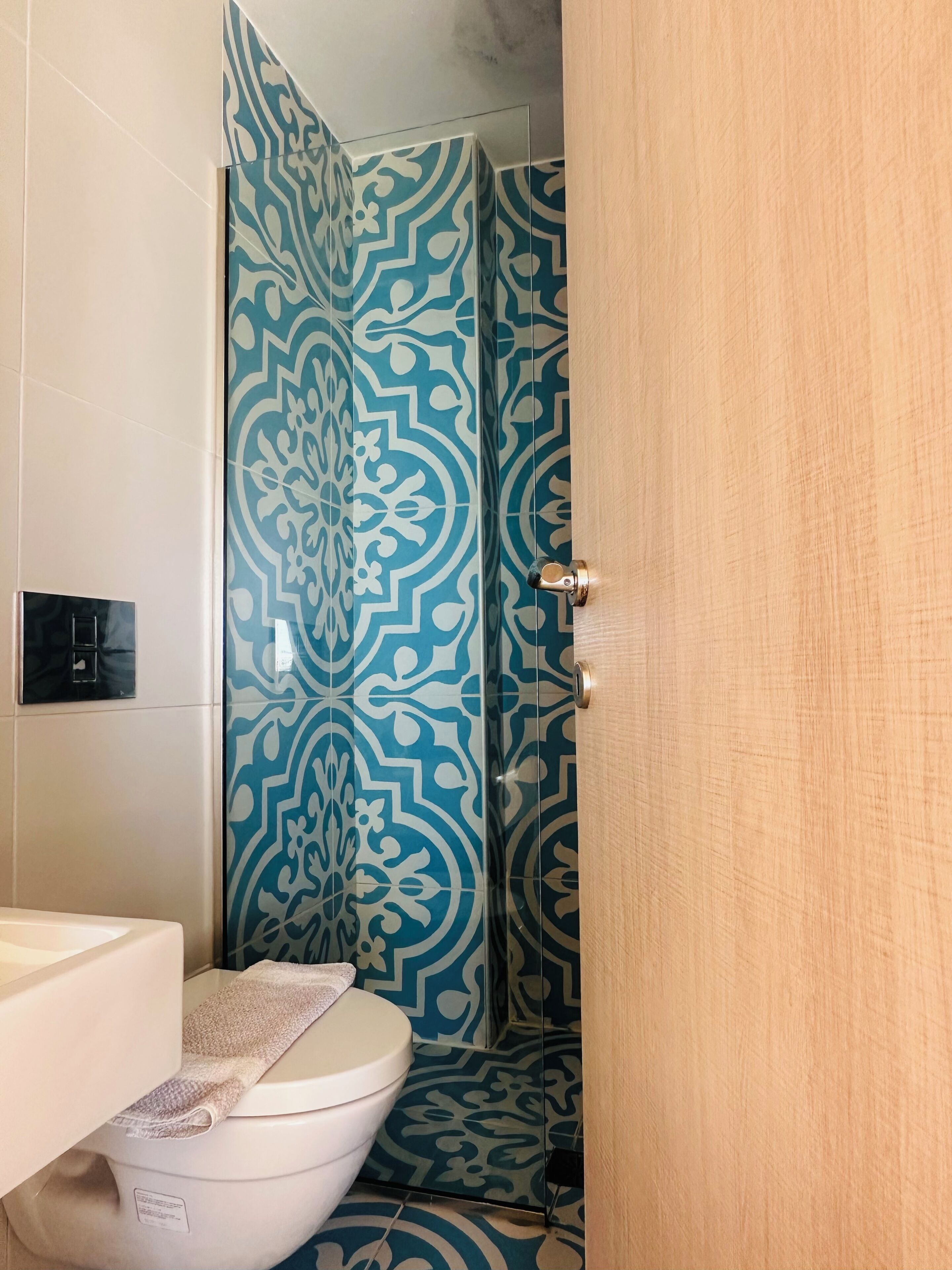 Un bagno con tenda da doccia decorata, un water e un lavandino.