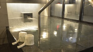 A wet floor with two white mugs on a tiled surface, a metal railing, and a patterned wall in the background. - Apa Hotel Saitama Shintoshin StationKita (Saitama)