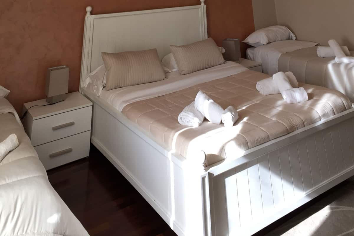 A neatly arranged bedroom with a bed, two bedside tables, and a nightstand.