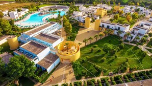 An aerial view of a resort with a swimming pool, multiple buildings, and landscaped areas. - Fruit Village Torre dell'Orso La Brunese (Melendugno)