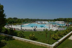 Una piscina al aire libre de temporada, sombrillas