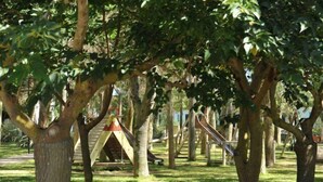 A playground with climbing structures and slides, surrounded by trees. - Fruit Village Torre dell'Orso La Brunese (Melendugno)