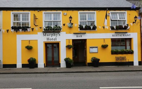 A yellow building with a sign for Murphy's Hotel, a bar, and a restaurant.