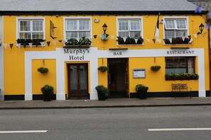 A yellow building with a sign for Murphy's Hotel, a bar, and a restaurant. - Murphy's Hotel (Tubbercurry)