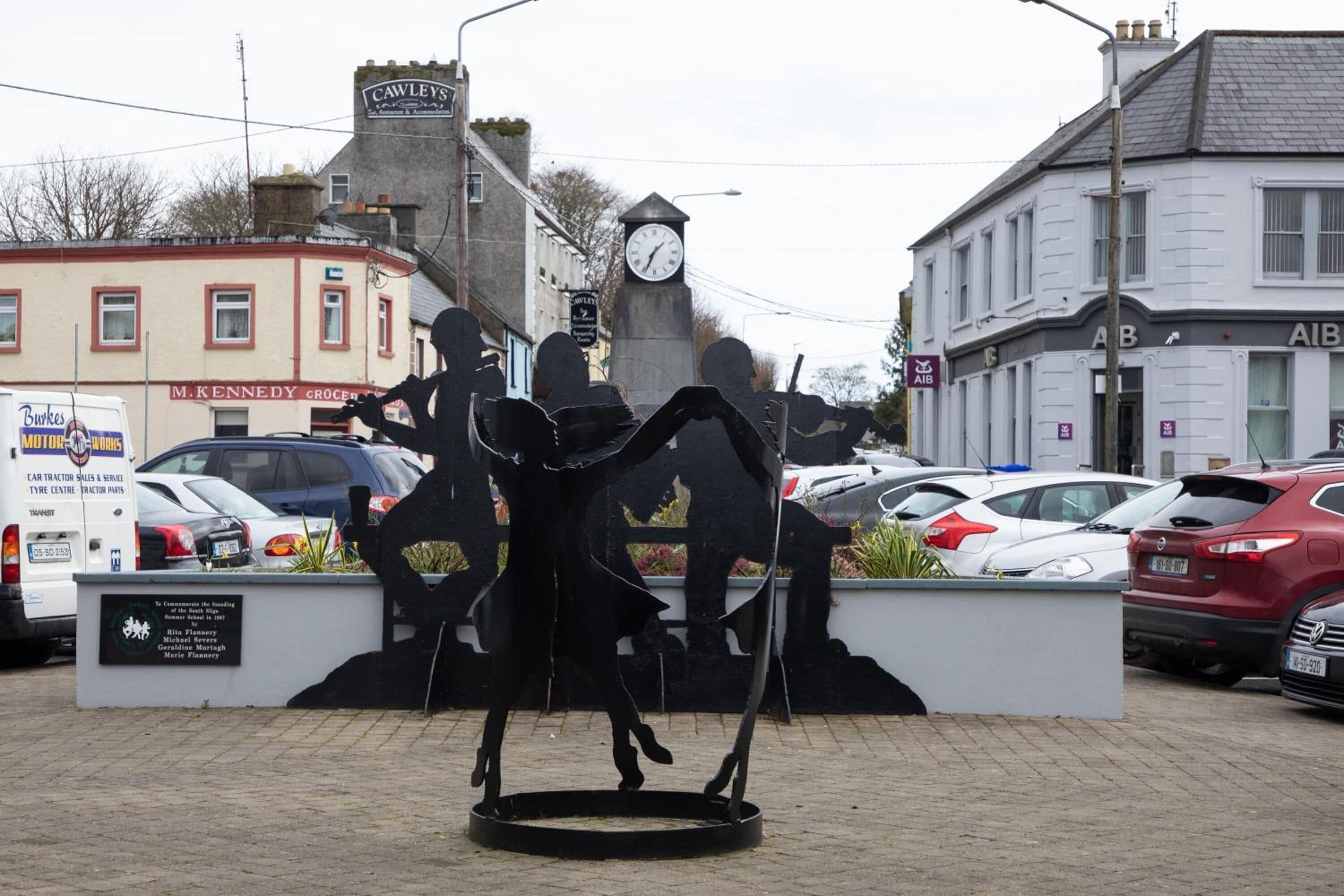 A statue of a man with a clock in the background.