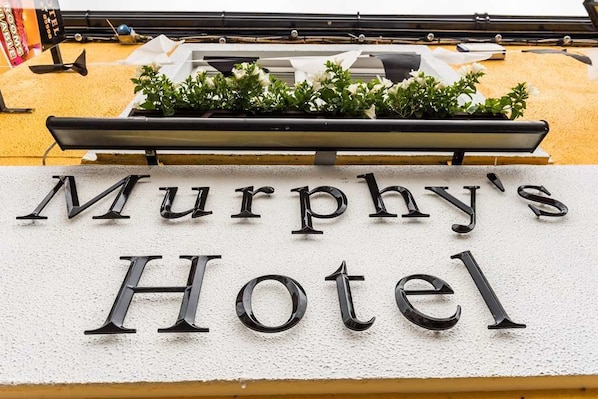 Placa de Murphy's Hotel com um vaso de plantas acima.