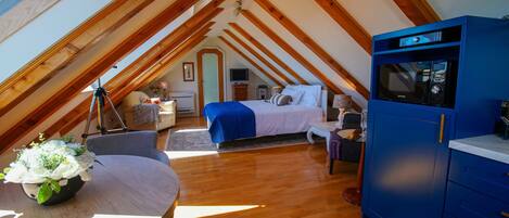 A bedroom with a bed, a blue cabinet, and a wooden ceiling.