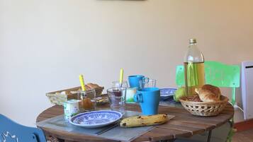 Une table à manger avec un plateau en bois rustique, entourée de chaises, et un tableau accroché au mur.