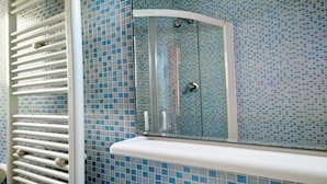 A bathroom with a shower, tiled walls, and a white radiator. - Cristina Rooms (Rome)