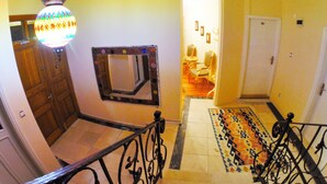 A staircase with a patterned rug, a wooden door, and a hanging light fixture. - Ottoman's Pearl Hotel (Istanbul)