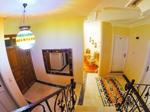 A staircase with a patterned rug, a wooden door, and a hanging light fixture. - Ottoman's Pearl Hotel (Istanbul)
