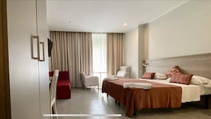 Una habitación de hotel con una cama, un escritorio, una silla y un televisor.
