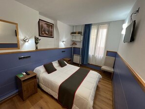 A hotel room with a bed, bedside table, lamp, and a chair. - Pensión Irune by Vivere Stays (San Sebastián)