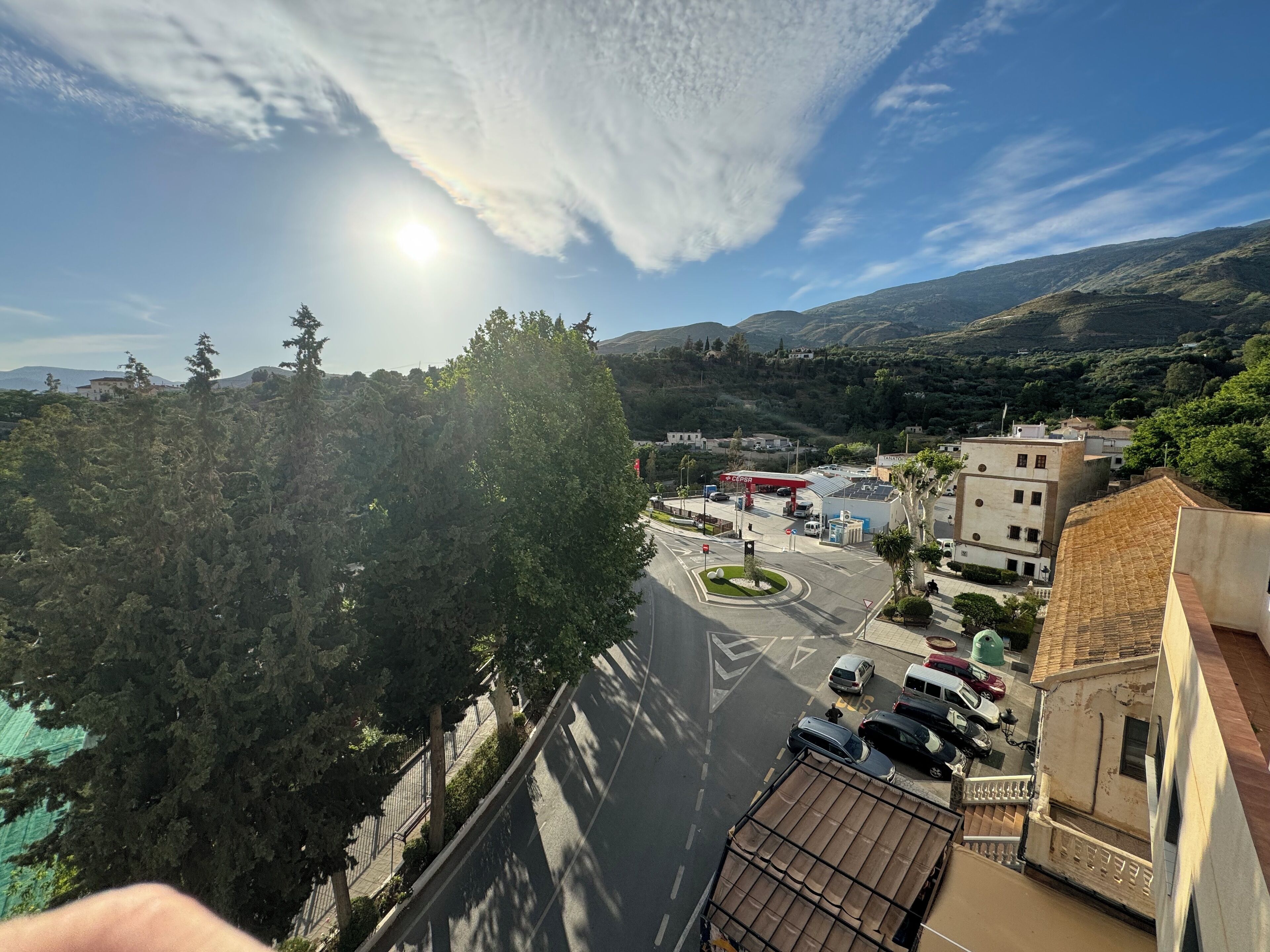 Une vue d’une ville avec une station-service, des bâtiments et une route.
