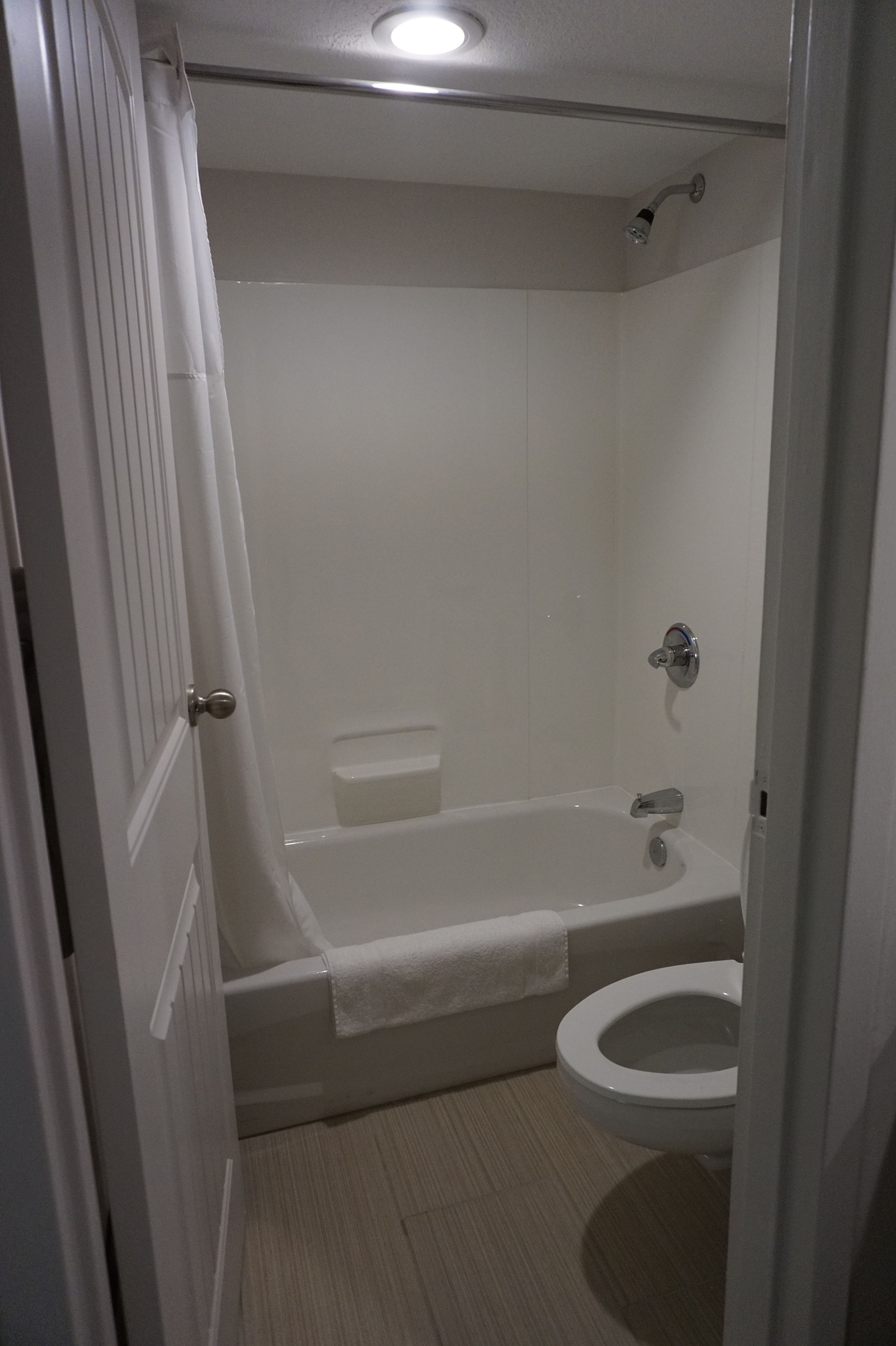 A bathroom with a bathtub, toilet, and shower.