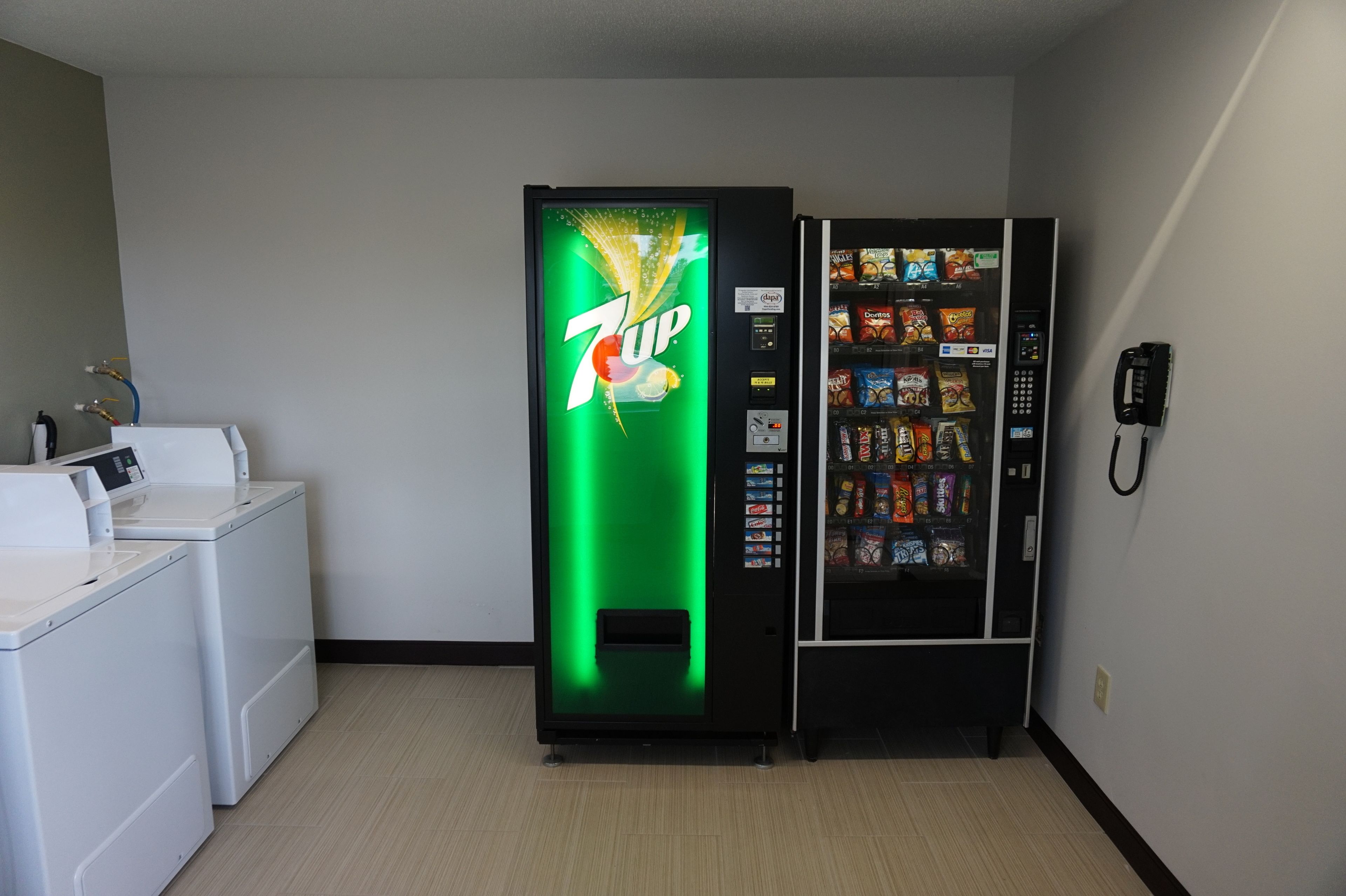 A 7UP vending machine and a phone in a hotel room.