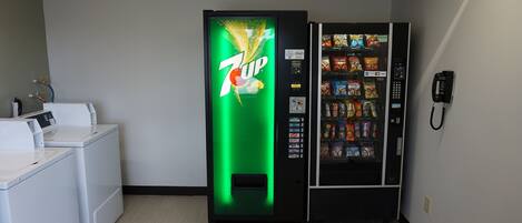 A 7UP vending machine and a phone in a hotel room.