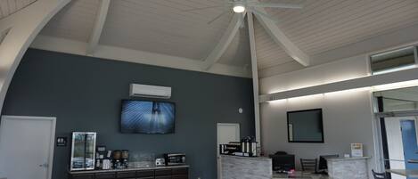 Un'ampia cucina con soffitto alto, un'isola centrale e un'area pranzo con sedie.