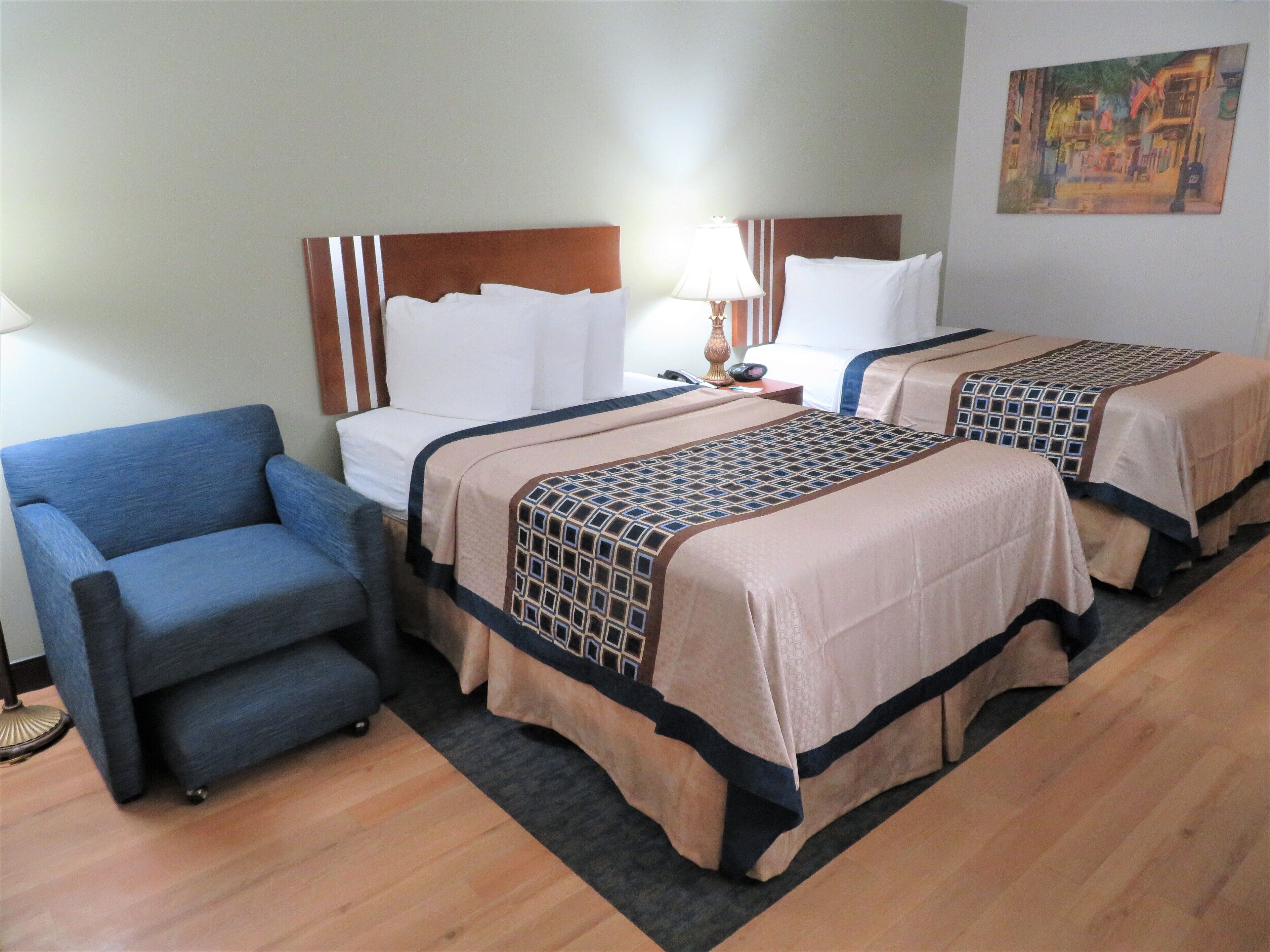 Habitación de hotel con dos camas, un sofá y una lámpara.