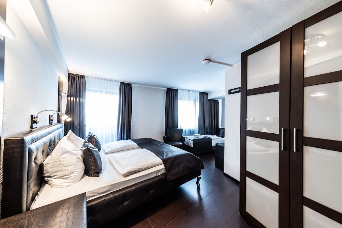 Une chambre d’hôtel moderne avec un grand lit, un bureau et une armoire.
