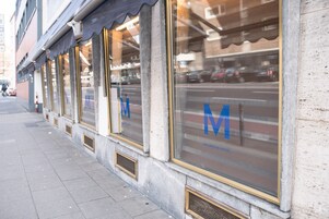 Fachada de hotel con ventanas amplias que muestran el nombre y el logotipo del establecimiento.