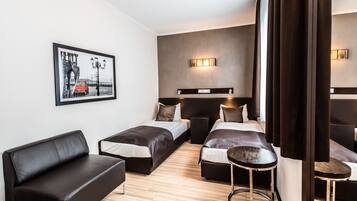 Una moderna camera d'albergo con un letto grande, una poltrona, un tavolino e uno specchio ampio.