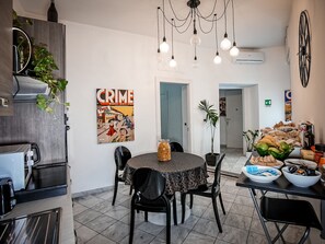 A modern kitchen with a dining area, featuring a round table, chairs, and a variety of food items. - Gate 40 (Rome)