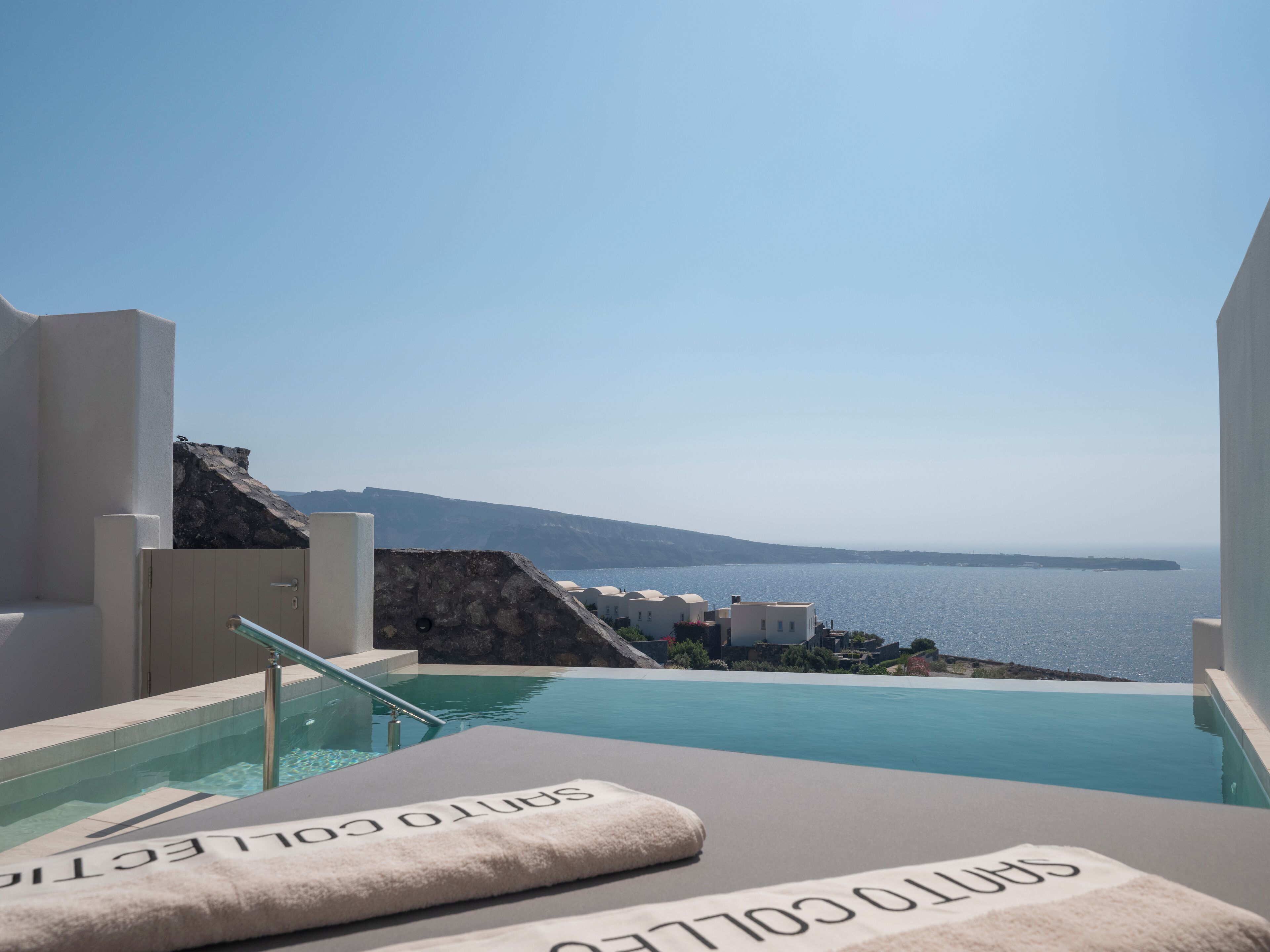Zona de piscina con vista al mar y un paisaje rocoso.