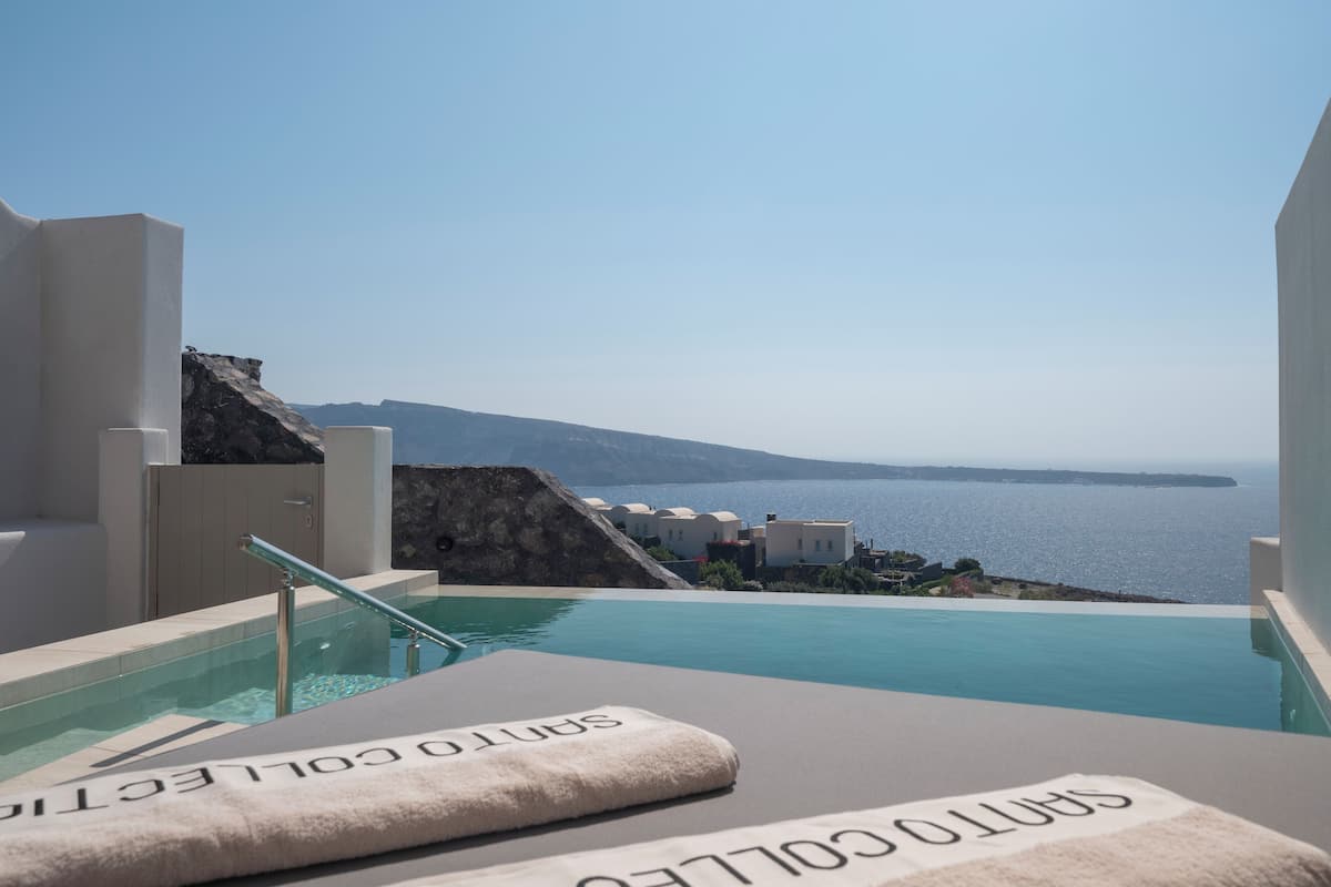 Ein Poolbereich mit Blick auf das Meer und eine felsige Landschaft.