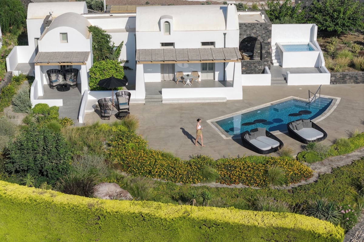 Eine moderne Villa mit Swimmingpool, Gartenmöbeln und einem angelegten Garten.