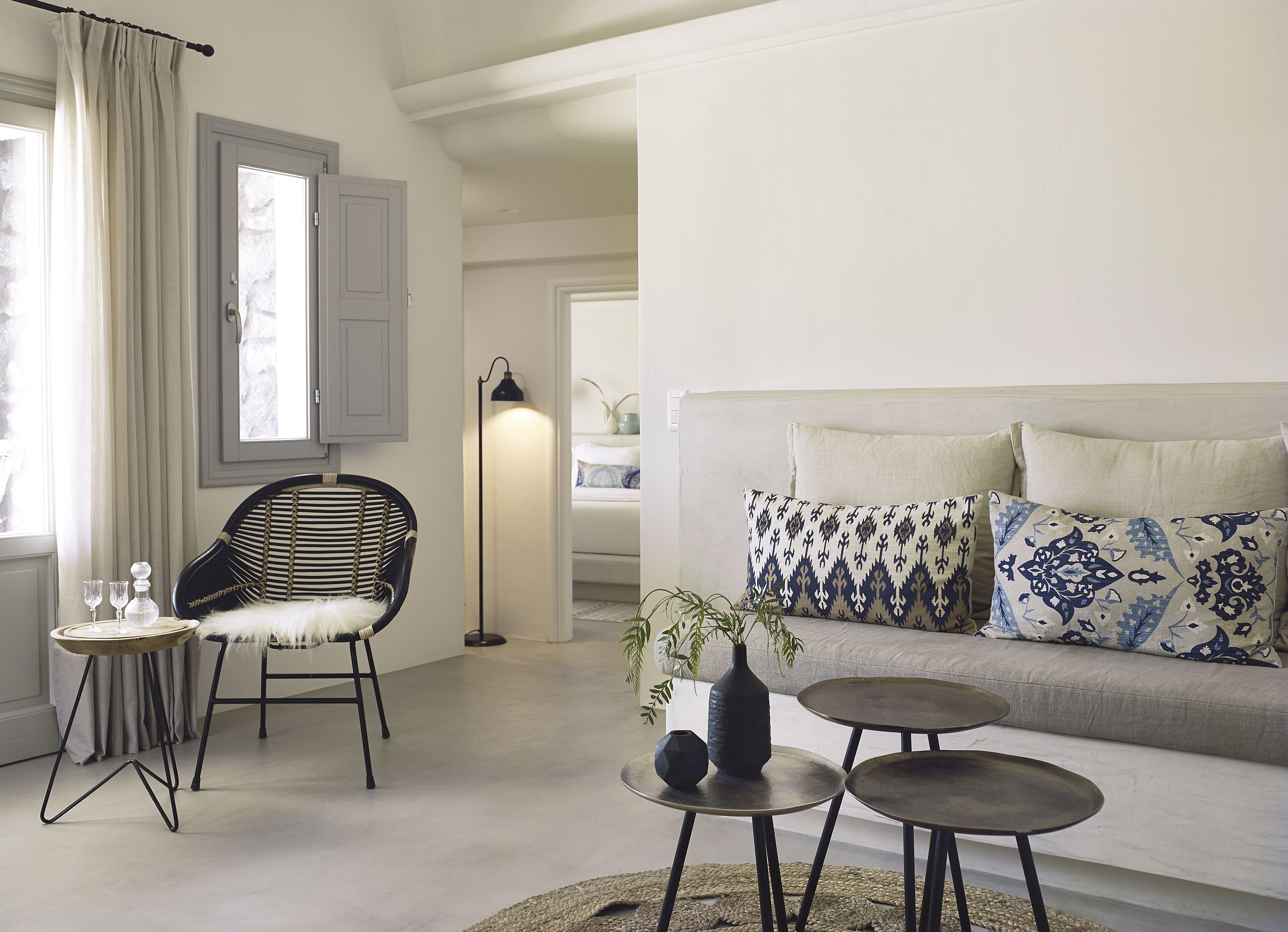 A modern living room with a sofa, a chair, a small table, and a floor lamp.