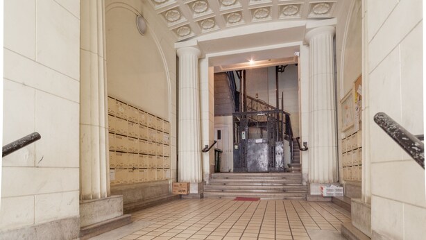 A grand staircase with a decorative ceiling and a view of a room with a large window. - Tatra 4 Studios (Budapest)