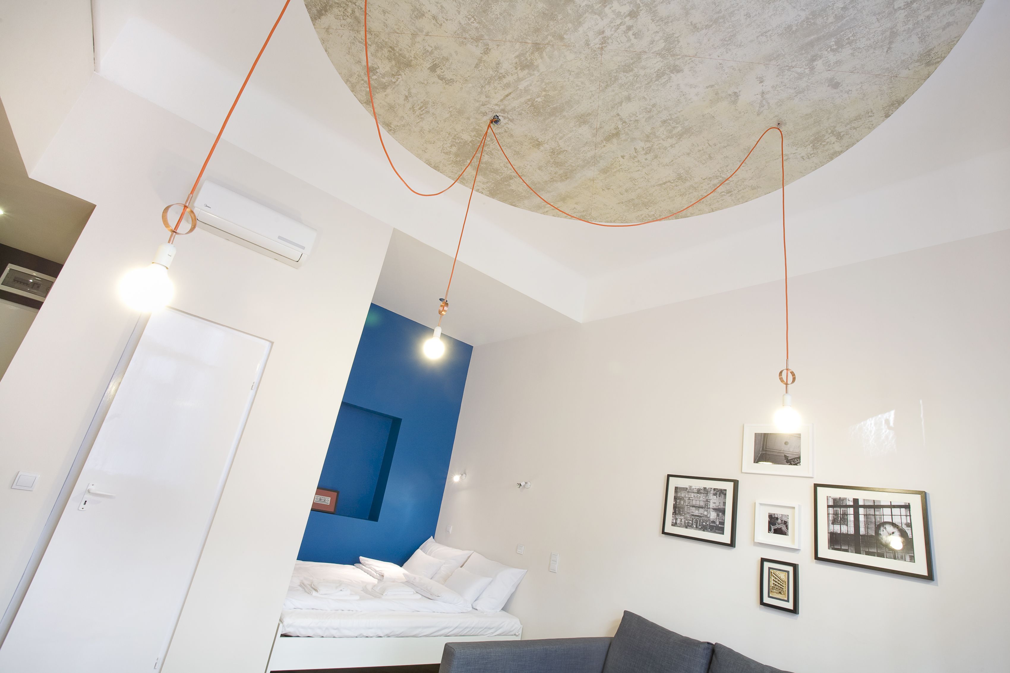 Une chambre moderne équipée d’un lit, d’un canapé et d’un climatiseur fixé au mur.
