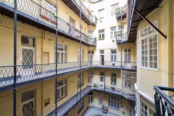 A multi-story building with balconies, windows, and a staircase.