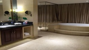 A modern bathroom with a large mirror, a bathtub, and a shower area. - Jialaite Garden International Hotel (Nanchang)