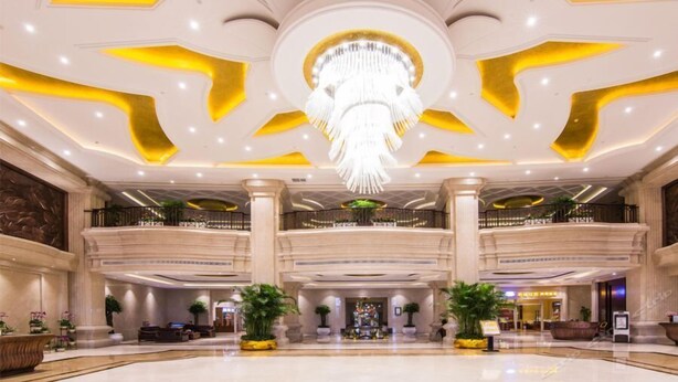 A spacious lobby with a grand chandelier, multiple floors, and a central seating area. - Jialaite Garden International Hotel (Nanchang)