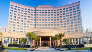 A large, multi-story hotel with a curved facade, featuring a central entrance with columns and a sign above it. - Jialaite Garden International Hotel (Nanchang)